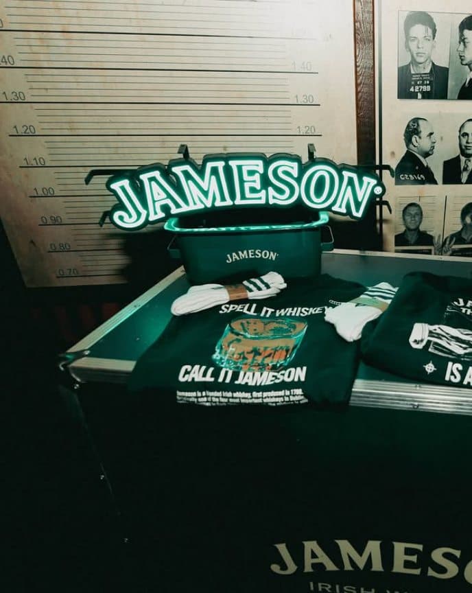 Pared de fichas policiales con la escala de altura y un neón de Jameson