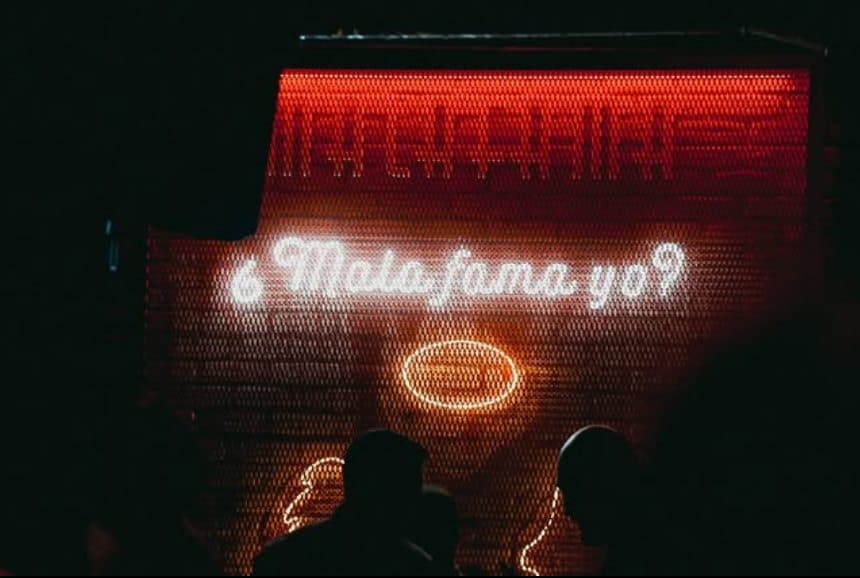 Neón rojo con el lema «¿Mala fama yo?» sobre la pista del club